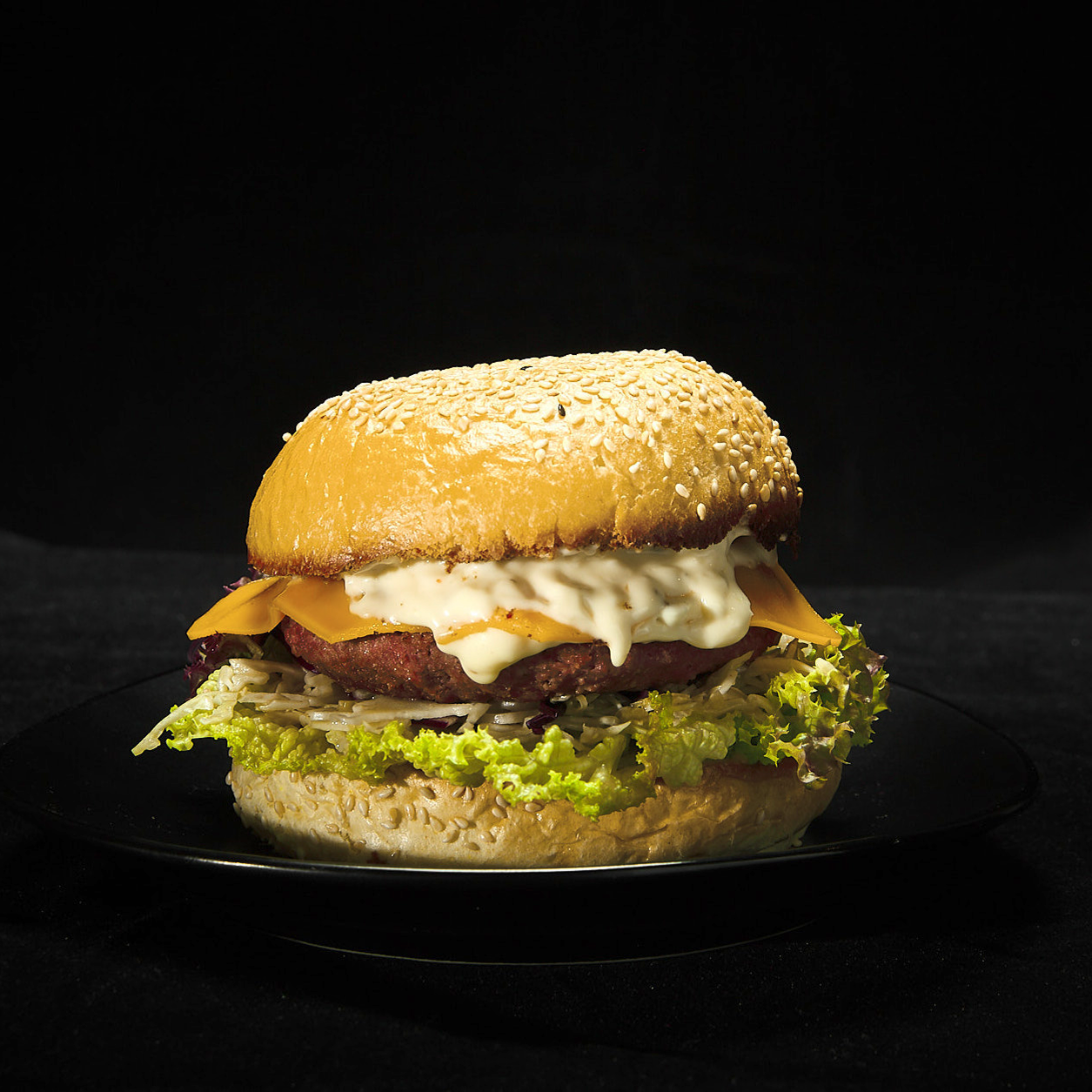Burger mit Redefine PRO Premium Burger, Cole Slaw, Golden Dakota Dressing, Burgersauce, White Smoked BBQ Dip, Lollo Rosso und bedda Scheiben cheddar style