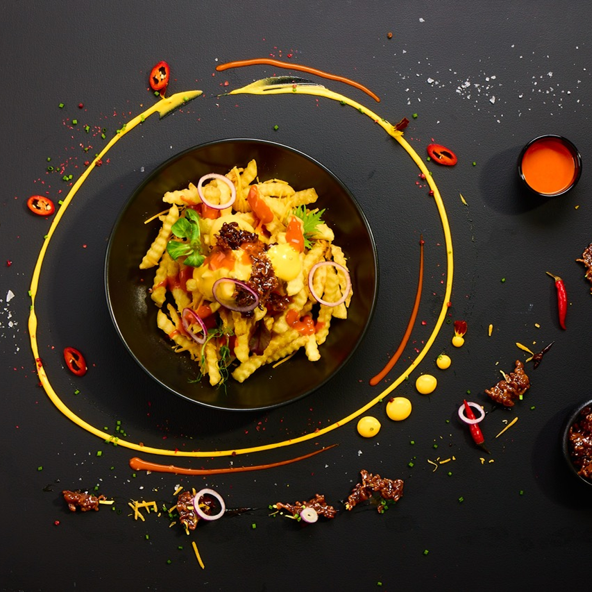 Loaded Fries mit BBQ Hackfleisch, Melted Cheese Dip, Chicago Fire Sauce, roten Zwiebeln, Schnittlauch und frischer Chili