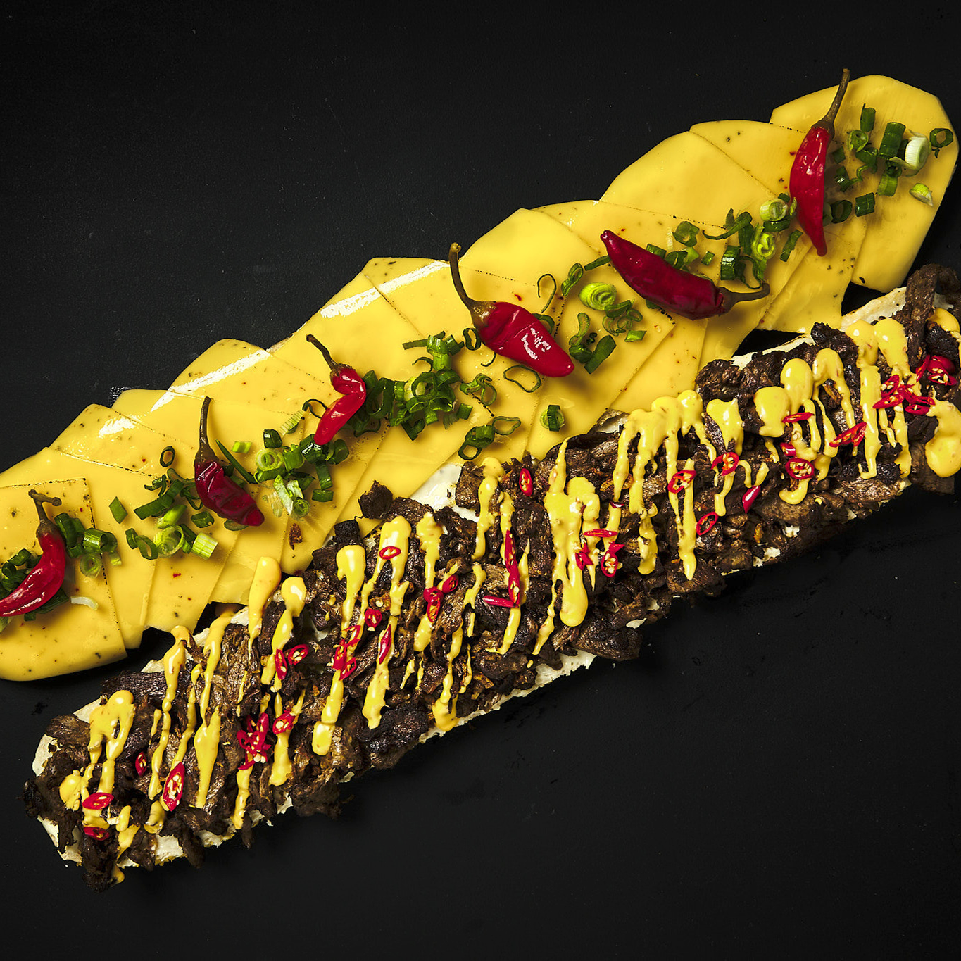 Großes Baguette mit Redefine PRO Pulled Beef, Burgersauce, bedda Scheiben Chili, bedda Cheddar Style Sauce, Jalapeños und Frühlingslauch