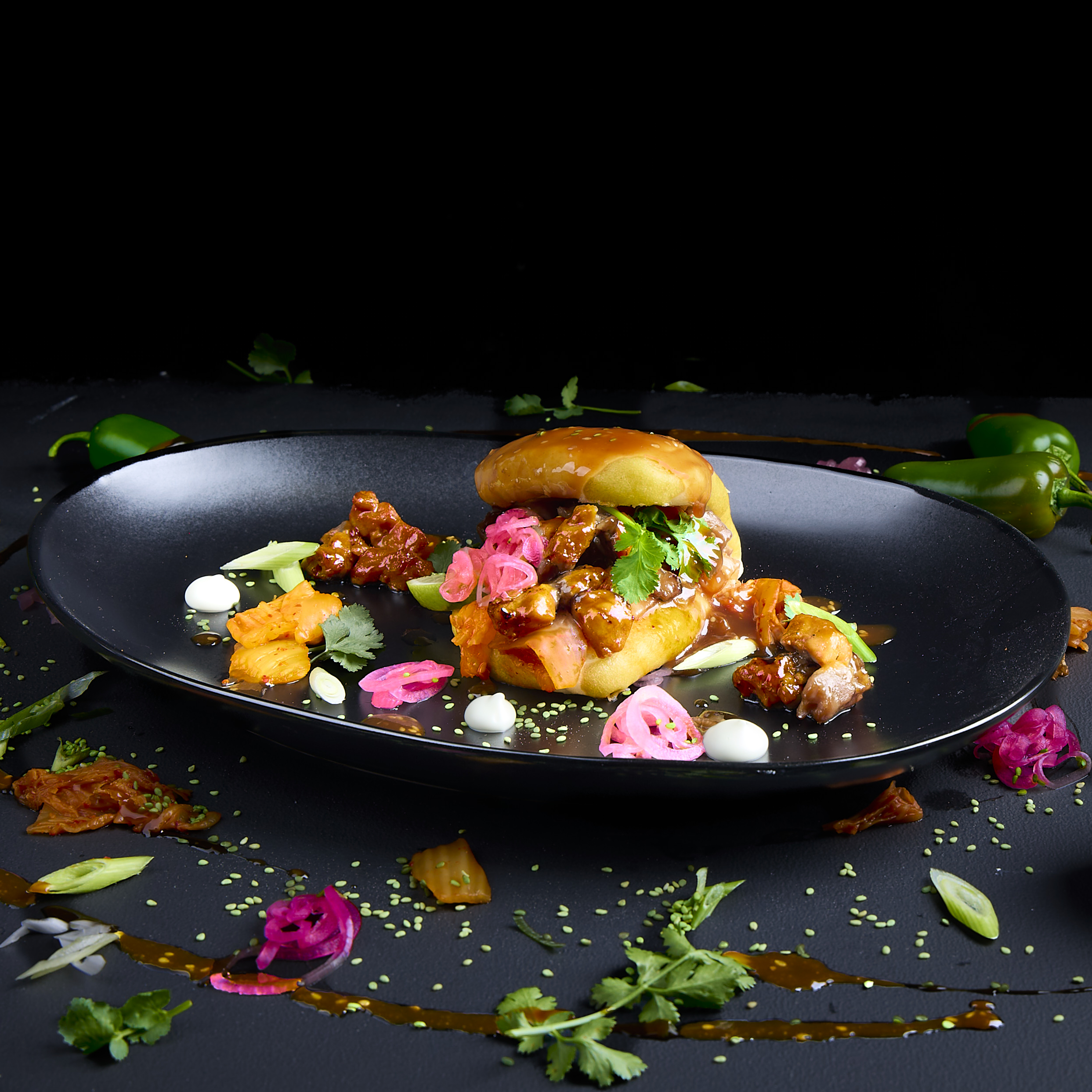 Korean Fusion Bao Bun mit Hähnchen, Kimchi, Koriander, Pink Onions, Sesam, Cinnamon Plum Sauce und Korean Jjang