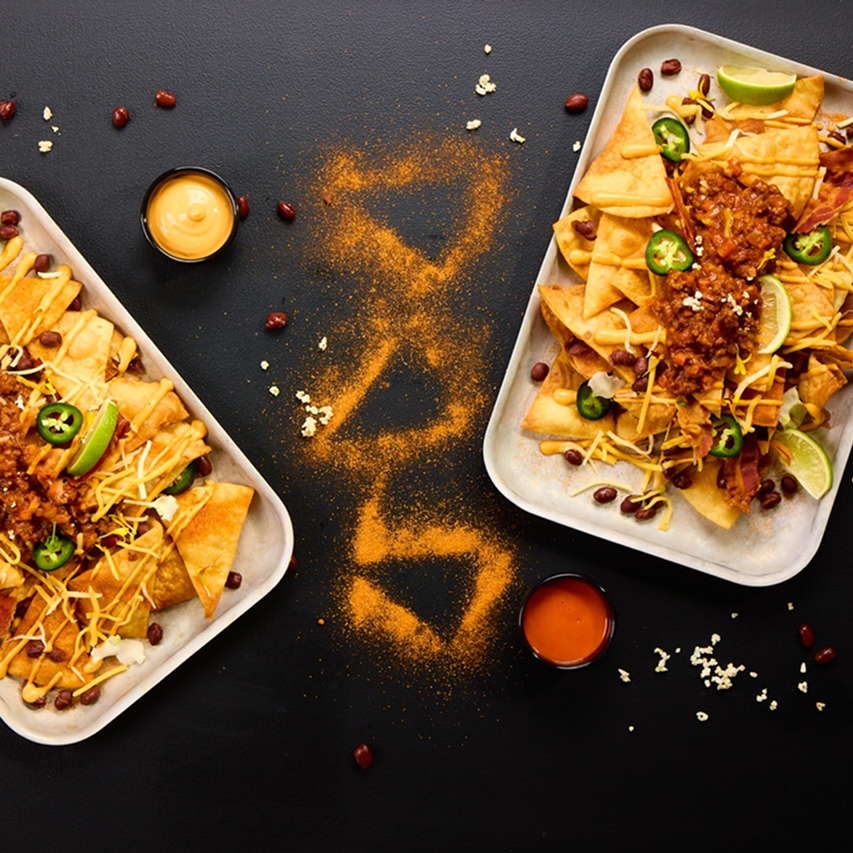 Belegte Nachos mit Hackfleischsauce, Cheese Dip, Kidneybohnen, Jalapeños und Chipotle Dip