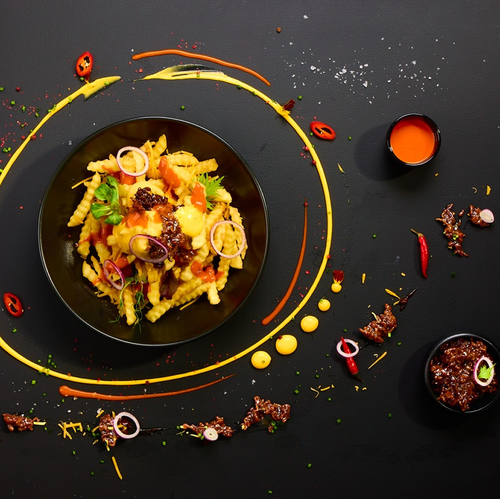 Loaded Fries mit BBQ Hackfleisch, Melted Cheese Dip, Chicago Fire Sauce, roten Zwiebeln, Schnittlauch und frischer Chili