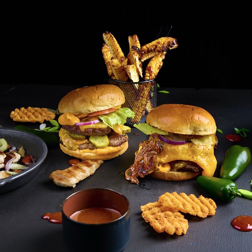 Cheeseburger mit Beef Patty, Cheddar, Zwiebeln, Gewürzgurken, Eisbergsalat und Giant Burger Sauce
