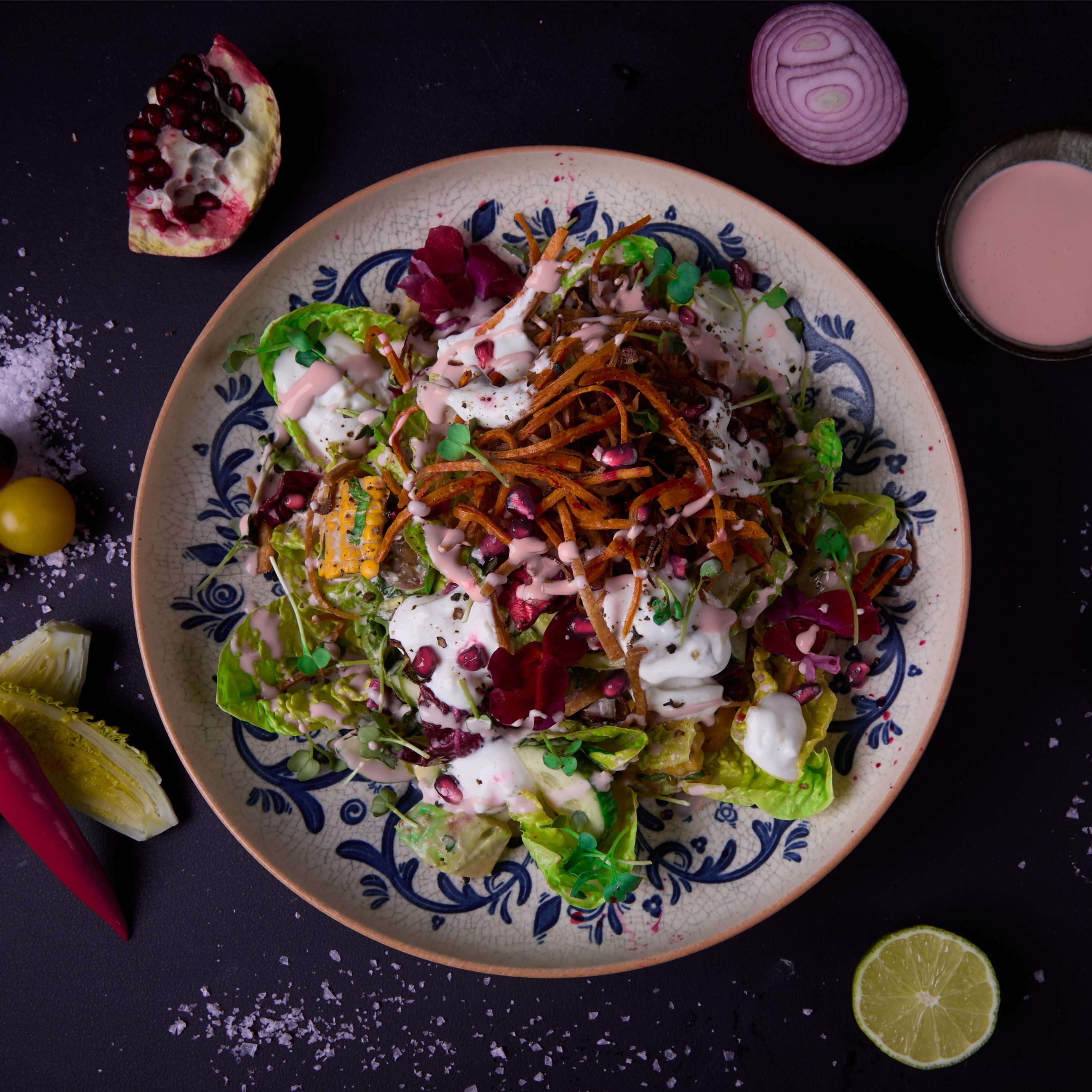 Frischer Salat mit Romanasalat, Radicchio, Avocado, Gurke, Kirschtomaten, Mais, roten Zwiebeln, Koriander, Minze, Chili und Himbeer-Distel-Dressing